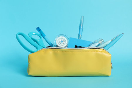Different stationery in pencil case on light blue background