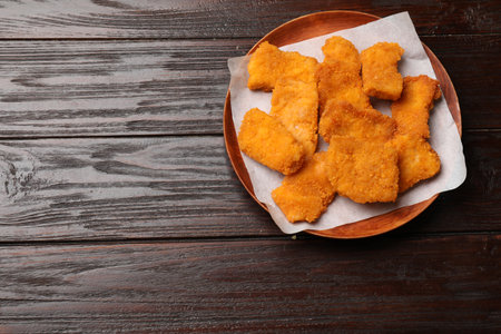 Tasty chicken nuggets on wooden table, top view. Space for textの写真素材