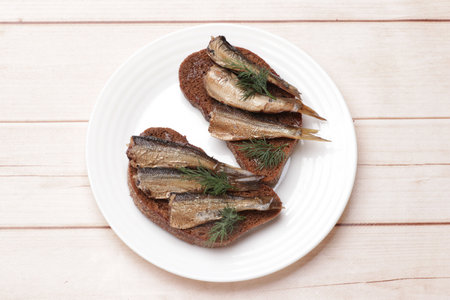 Delicious sandwich with sprats and dill on white wooden table, top viewの写真素材