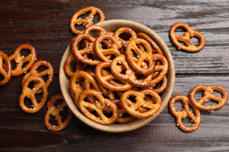 Tasty pretzel crackers on wooden table, top view