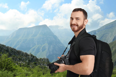 Photographer with camera and backpack in mountainsの写真素材