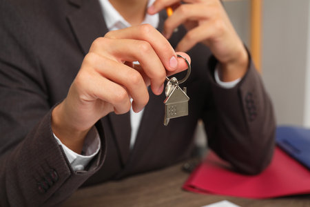 Real estate agent with house key at table, closeupの写真素材