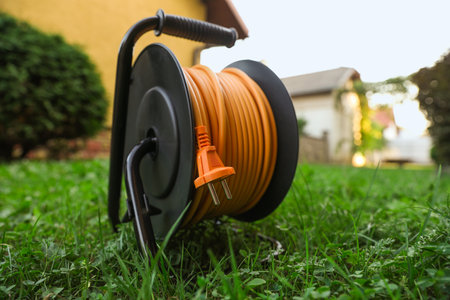 One extension cord reel on green grass outdoorsの写真素材