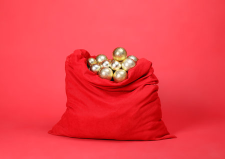 Santa Claus bag with baubles on red backgroundの写真素材