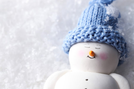 Cute decorative snowman on artificial snow, top view. Space for textの写真素材