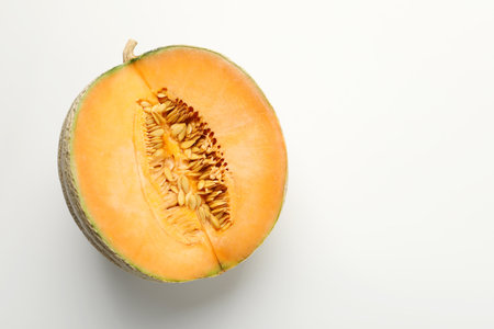 Half of fresh Cantaloupe melon on white table, top view. Space for textの写真素材