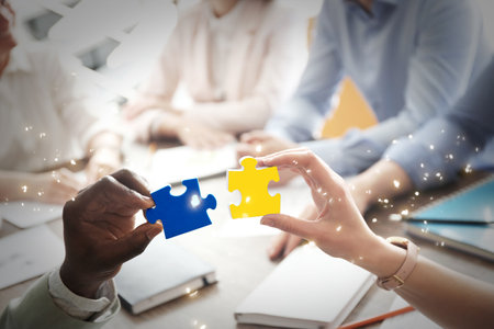 People with puzzle pieces at office, closeup. Concept of partnershipの写真素材