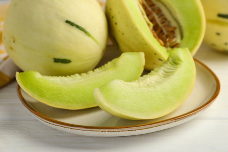 Fresh whole and cut honeydew melons on white wooden table, closeupの写真素材
