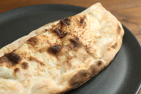 Plate with tasty calzone on table, closeupの写真素材