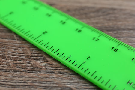 One green ruler on wooden table, closeupの写真素材