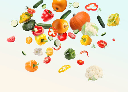 Many different fresh vegetables in air on light backgroundの写真素材