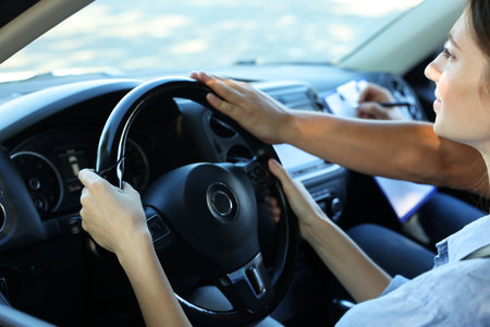 Driving school. Student passing driving test with examiner in car, closeupの写真素材