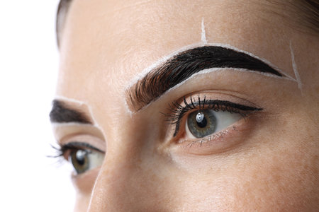 Young woman during henna eyebrows dyeing procedure on light background, closeupの写真素材