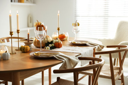 Stylish dining room with beautiful table setting and autumn decorの写真素材