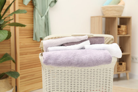 Wicker basket full of laundry in bathroom, closeupの写真素材