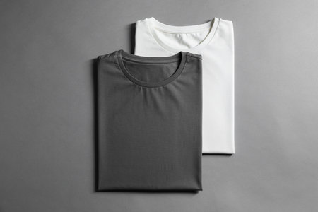 Different blank t-shirts on gray background, top view. Mockup for design