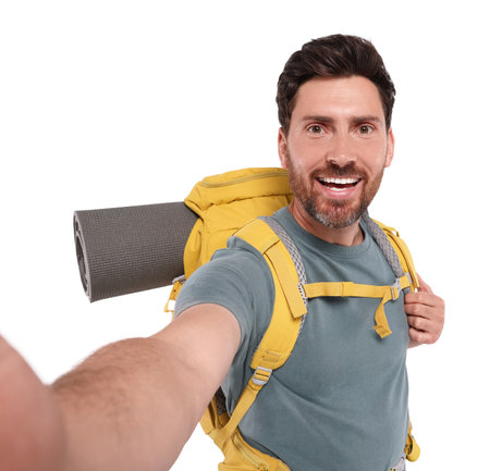Happy man with backpack taking selfie on white background. Active tourismの写真素材