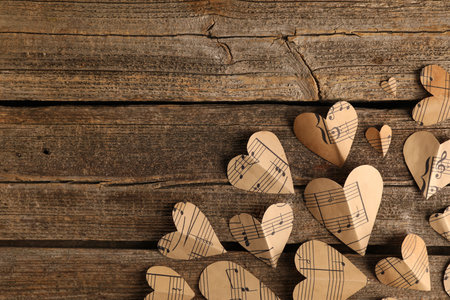 Paper hearts with notes on wooden table, flat lay. Space for textの写真素材