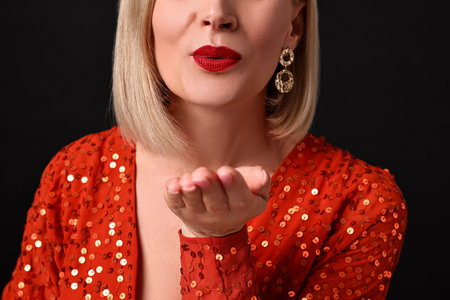 Woman sending air kiss on black background, closeupの写真素材