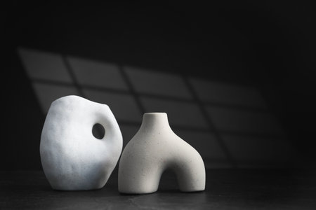 Stylish ceramic vases on black background. Space for textの写真素材