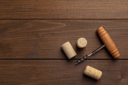 Corkscrew and corks on wooden table, top view. Space for textの写真素材