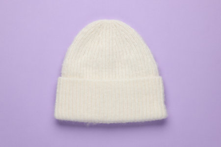 Warm woolen hat on lilac background, top viewの写真素材