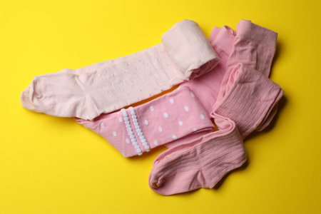 Pink child's tights on yellow background, flat layの写真素材