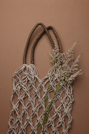 Handmade macrame shopping bag with spikes on brown background, top viewの写真素材