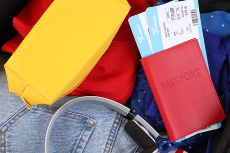 Different clothes, headphones and passport with tickets, closeup. Travel luggageの写真素材