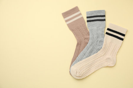 Different comfortable socks on beige background, flat lay. Space for textの写真素材