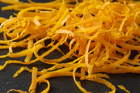 Pile of fresh orange zest on black table, closeupの写真素材