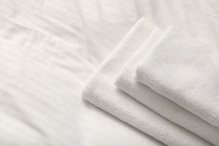 Stack of towels on clean lines indoors, closeup. Space for textの写真素材