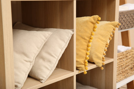 Clean pillows on shelving unit indoors. Home textile storageの写真素材