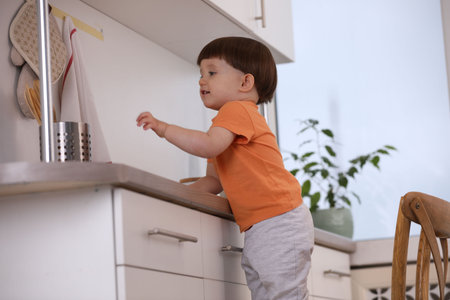 Little boy playing with kitchen appliances indoors. Dangerous situationの写真素材
