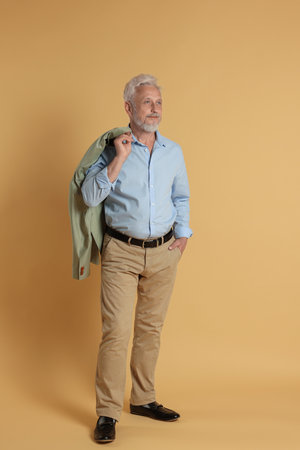 Full length portrait of senior man on beige backgroundの写真素材