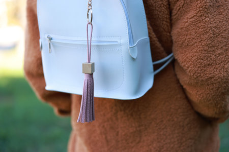 Woman with pink leather keychain on her backpack outdoors, closeupの写真素材