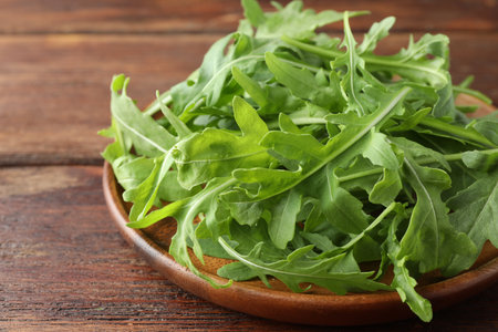 Fresh green arugula leaves on wooden table, closeupの写真素材