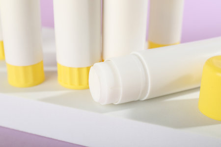 Many glue sticks on violet background, closeupの写真素材