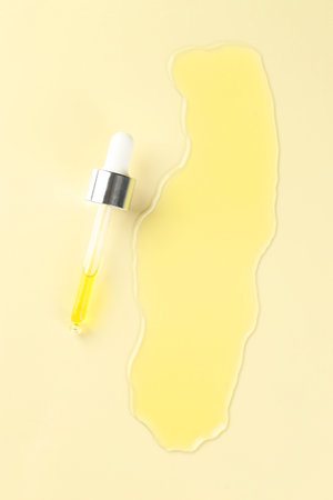 Cosmetic oil and pipette on dark beige background, top viewの写真素材