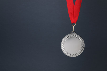 Silver medal with red ribbon on dark gray background, space for textの写真素材