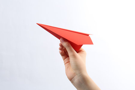 Woman with red paper plane on white background, closeupの写真素材