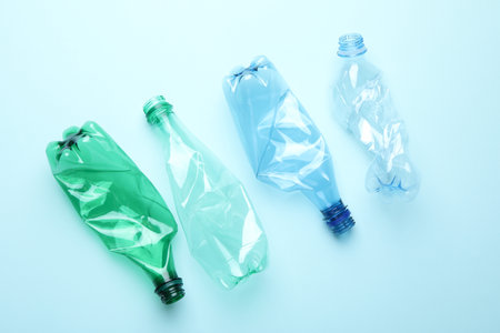 Crumpled plastic bottles on light blue background, flat layの写真素材