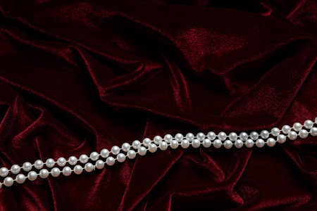 Beautiful pearl necklace on red cloth, top view. Space for textの写真素材