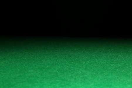 Green poker table against black background, closeupの写真素材