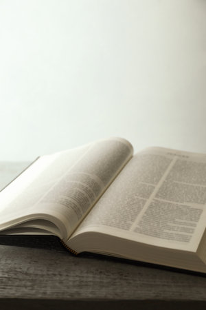 Open Holy Bible in English language on wooden table, closeup. Space for text