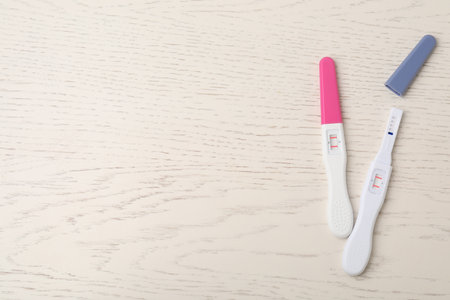 Two pregnancy tests on white wooden table, top view. Space for textの写真素材