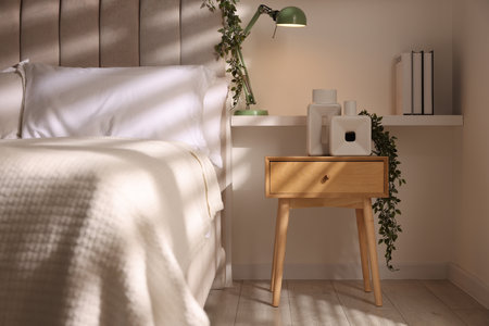 Stylish living room interior with bed, bedside table and lampの写真素材