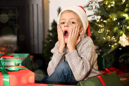 Person showing surprised expression with Christmas gifts at homeの写真素材