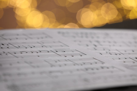 Sheet of musical notes against blurred lights, closeup. Bokeh effectの写真素材