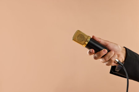 Man with microphone on beige background, closeup. Space for textの写真素材